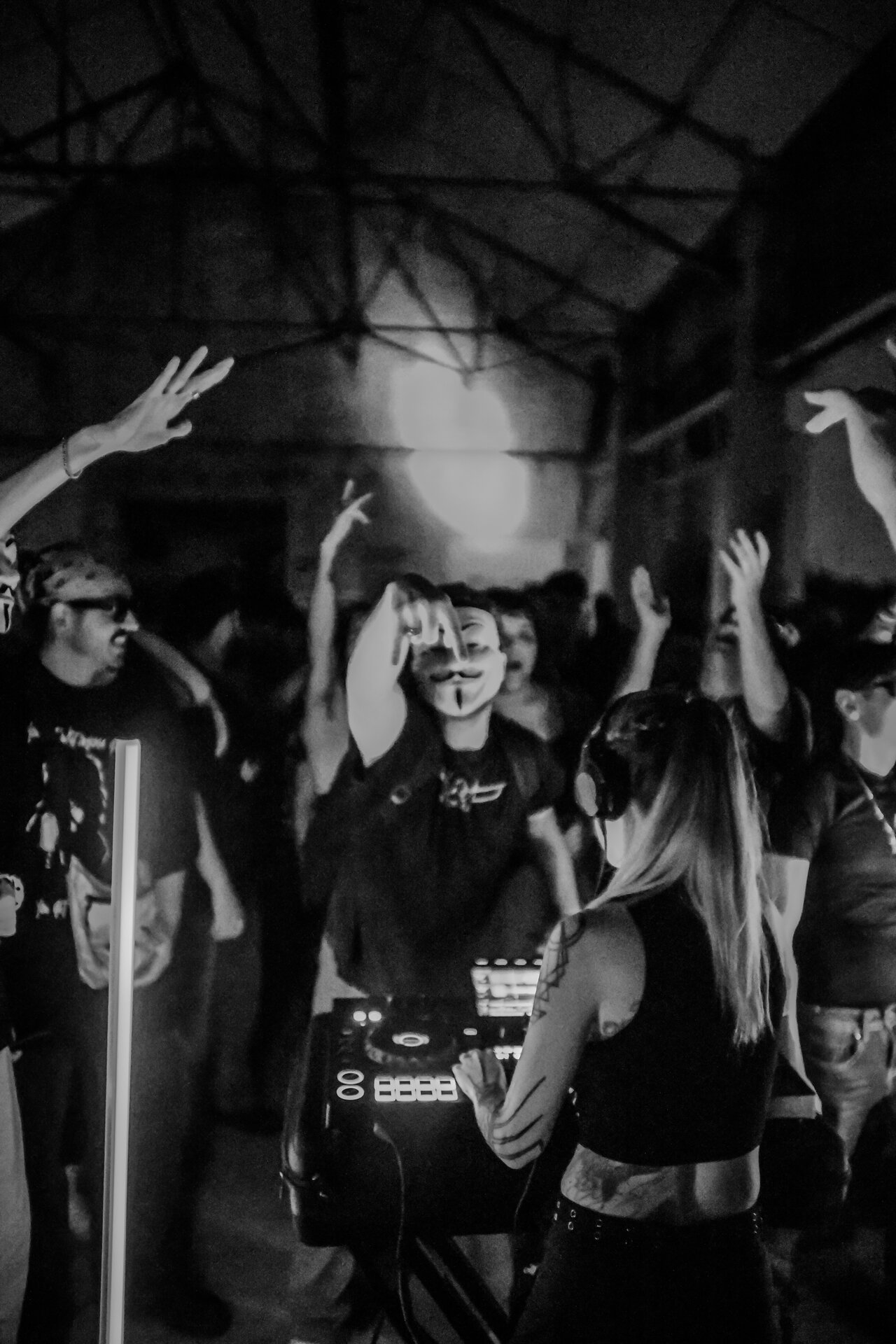 Producer working the booth during a late-night warehouse set